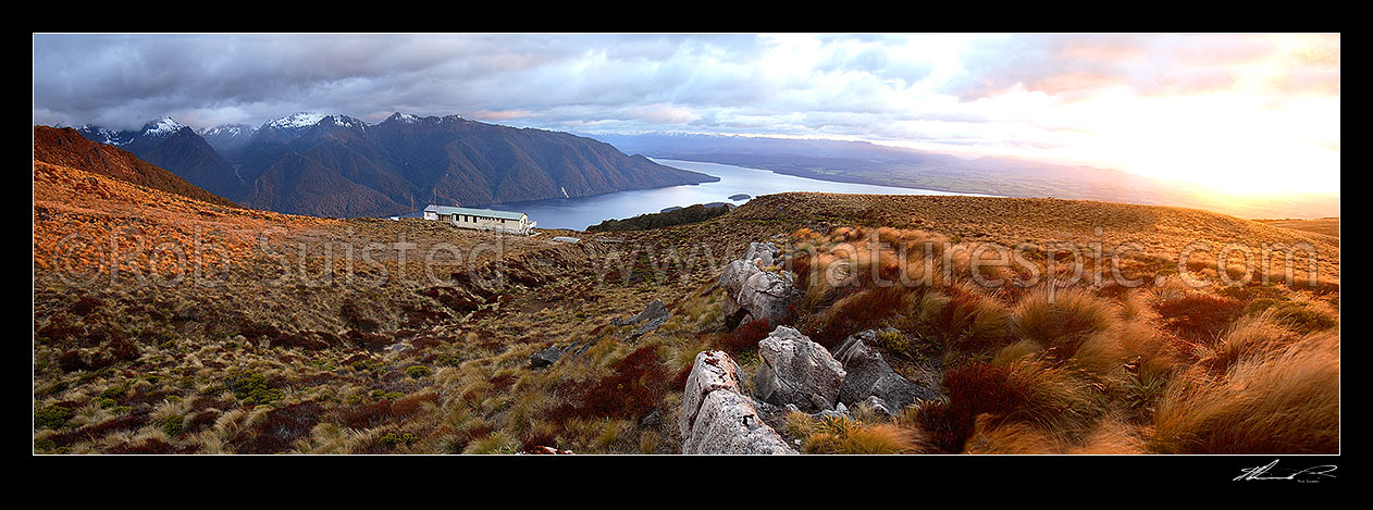 Image of Sunrise on Luxmore Hut, first hut on Kepler Track Great Walk. Lake Te Anau and Murchison Mountains beyond. Dawn, Fiordland National Park, Southland District, Southland Region, New Zealand (NZ) stock photo image