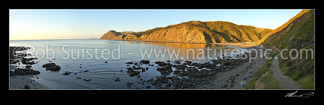 Image of Calm evening panoramic view of coastal settlement of Makara Beach and Ohariu Bay. Mana Island visible in distance, Makara Beach, Wellington City District, Wellington Region, New Zealand (NZ) stock photo image