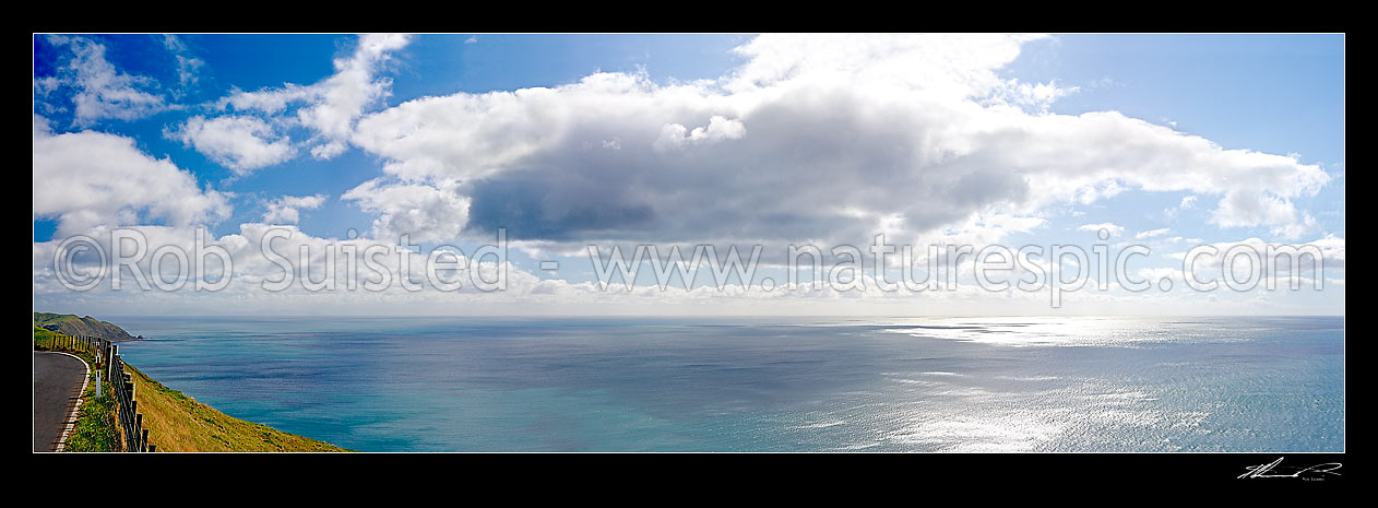 Image of White clouds and blue sky over a shimmering sea, panorama viewed from the summit of the Paekakariki Hill Road, Paekakariki, Kapiti Coast District, Wellington Region, New Zealand (NZ) stock photo image