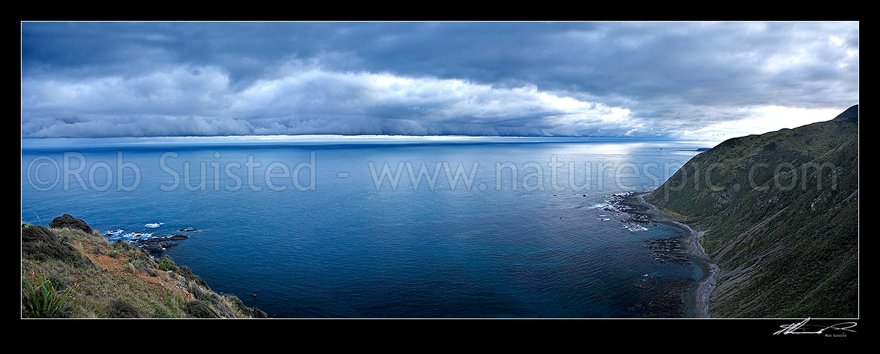 Image of Very dramatic southerly storm front approaching over Cook Strait and Wellington South Coast. Viewed from Sinclair Head. South Island visible under cloud bank., Cook Strait, Wellington City District, Wellington Region, New Zealand (NZ) stock photo image