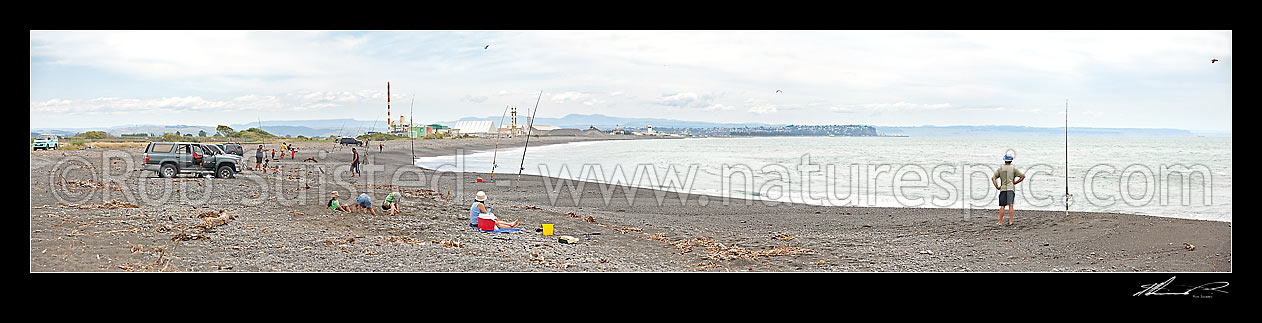 Image of Panorama of families picnicking and recreational fishing on Napier foreshore near the Tukituki, Ngaruroro and Clive River mouths. Christmas Day. Awatoto fertiliser plant behind, Clive, Napier City District, Hawke's Bay Region, New Zealand (NZ) stock photo image