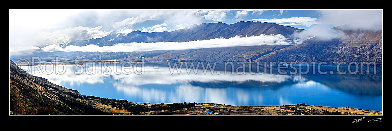 Image of Lake Ohau, looking towards the Ben Ohau Range. Long white cloud reflected and hanging over lake on a perfectly calm still day, Twizel, MacKenzie District, Canterbury Region, New Zealand (NZ) stock photo image