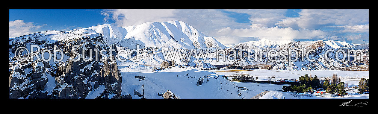 Image of Castle Hill Station merino sheep in heavy winter snows. Castle Hill limestone rock climbing area left. Craigieburn Range distant. Panorama, Castle Hill, Selwyn District, Canterbury Region, New Zealand (NZ) stock photo image