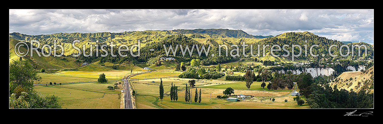 Image of Mangaweka township visible beyond farmland and white siltstone cliffs above the Rangitikei River. North Island main trunk line left. Panorama, Mangaweka, Rangitikei District, Manawatu-Wanganui Region, New Zealand (NZ) stock photo image