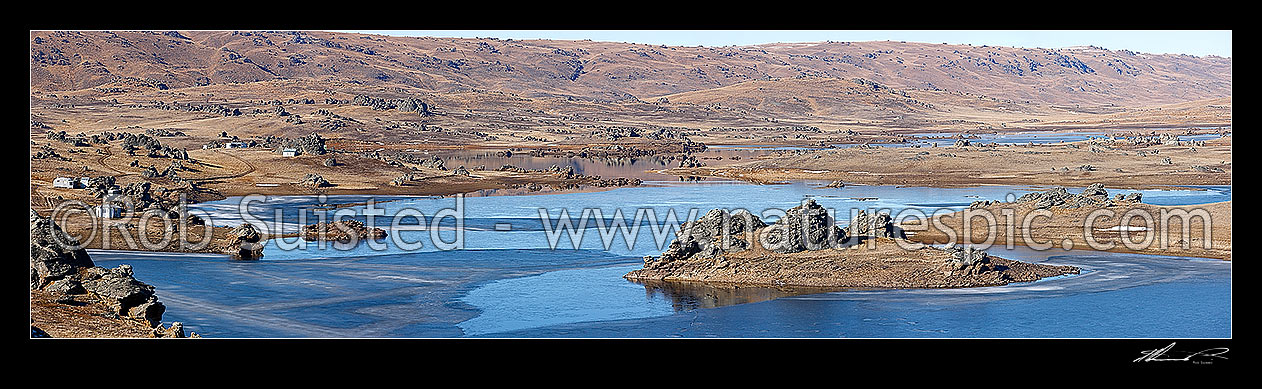 Image of Poolburn reservior frozen in winter. Fishing baches and cribs around edge. Lord of the Rings location Rohan. Panorama, Ida Burn Valley, Central Otago District, Otago Region, New Zealand (NZ) stock photo image