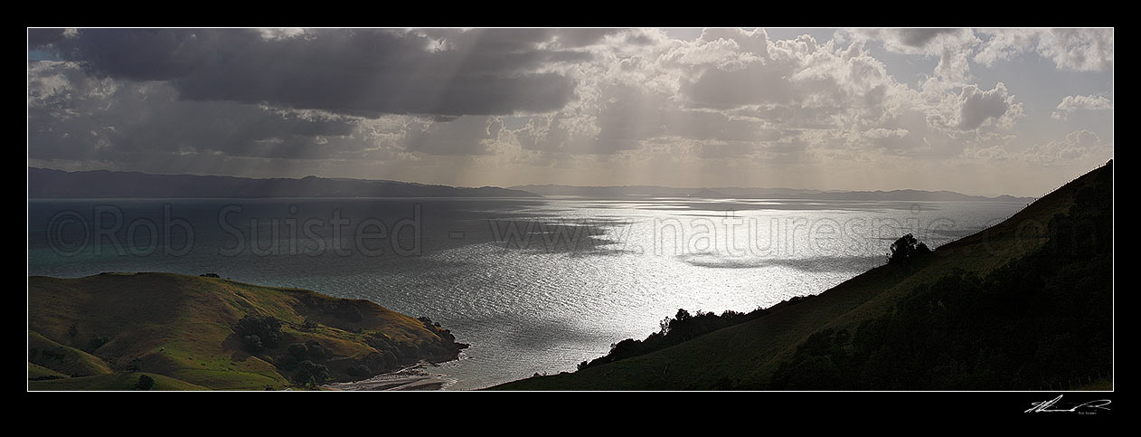 Image of Hauraki Gulf panorama. Moody sunshafts and clouds over sea near Kirita Bay, Coromandel Peninsula, looking towards Auckland, Coromandel, Thames-Coromandel District, Waikato Region, New Zealand (NZ) stock photo image