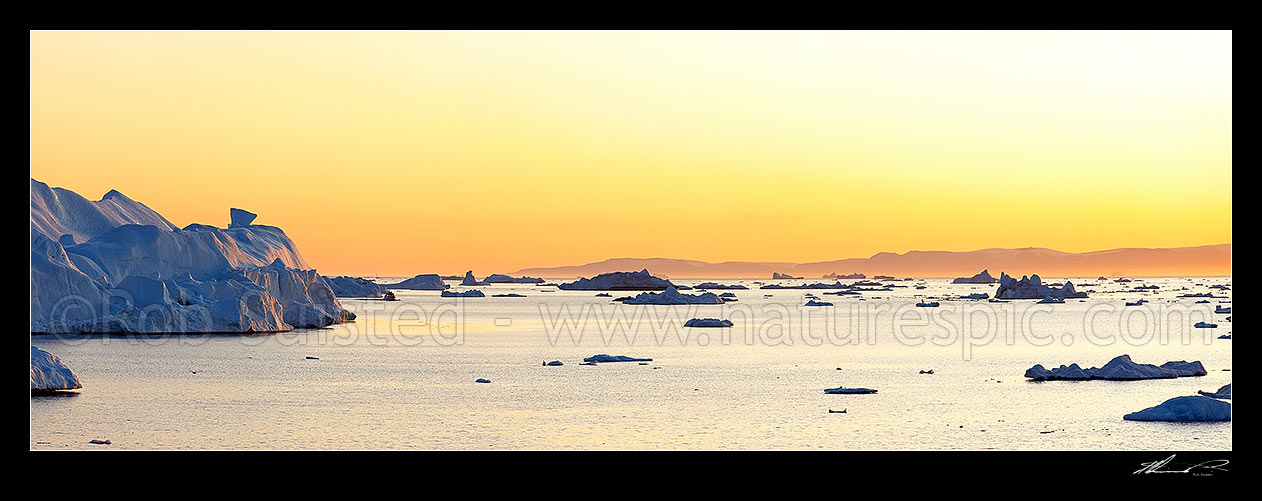 Image of Ilulissat Icefjord, giant icebergs at entrance to Ilulissat Kangerlua after leaving the Jakobshavn Isbr glacier. Sunset and fishing boat panorama, Ilulissat, Greenland stock photo image