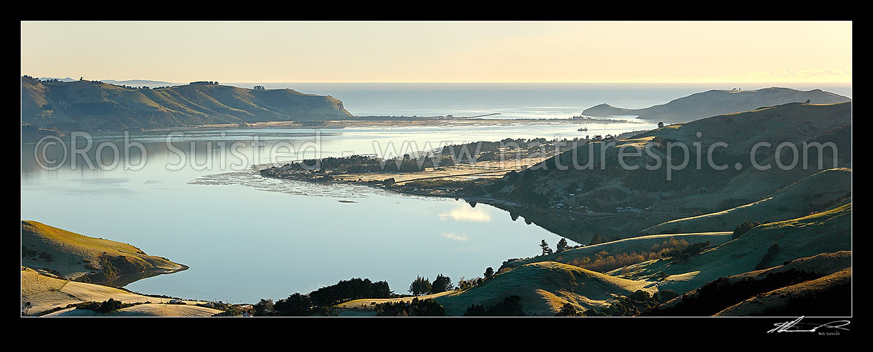 Image of Otago Harbour entrance at dawn looking past Harwood to Aramoana (left), The Spit, the Mole, and Taiaroa Head (right). Panorama, Otago Peninsula, Dunedin City District, Otago Region, New Zealand (NZ) stock photo image