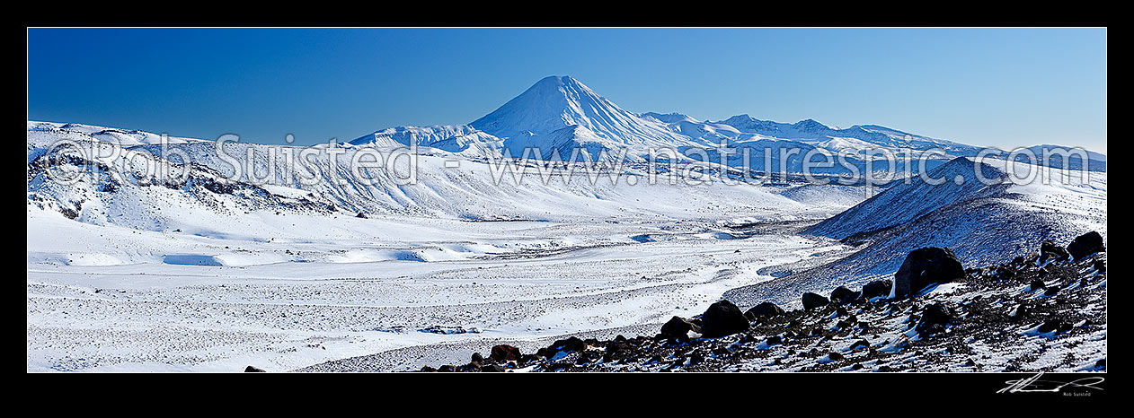 Image of Rangipo desert with Mt Ngauruhoe and Mt Tongariro behind, in winter snow. Mangatoetoenui stream. Round the Mountain (Mt Ruapehu) Track, Tongariro National Park, Ruapehu District, Manawatu-Wanganui Region, New Zealand (NZ) stock photo image