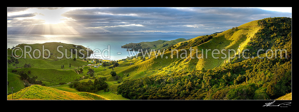 Image of Hauraki Gulf panorama. Moody sunshafts and clouds over sea near Kirita Bay, Coromandel Peninsula, looking towards Auckland. Stunning luch farmland panorama, Coromandel, Thames-Coromandel District, Waikato Region, New Zealand (NZ) stock photo image