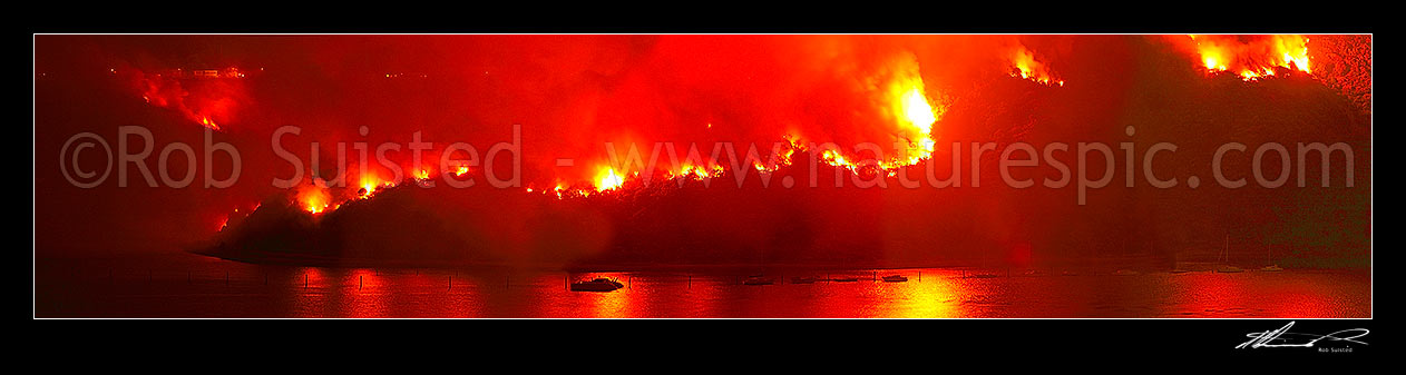 Image of Giant wild bushfire on the Titahi Bay Peninsula with Yachts and Porirua Harbour in foreground. Onepoto and Gloaming Hill left. Nighttime panorama, Titahi Bay, Porirua City District, Wellington Region, New Zealand (NZ) stock photo image