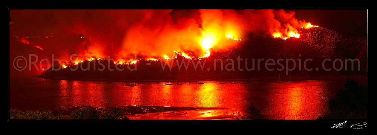 Image of Giant wild bushfire on the Titahi Bay Peninsula with Yachts and Porirua Harbour in foreground. Onepoto and Gloaming Hill left. Nighttime panorama, Titahi Bay, Porirua City District, Wellington Region, New Zealand (NZ) stock photo image