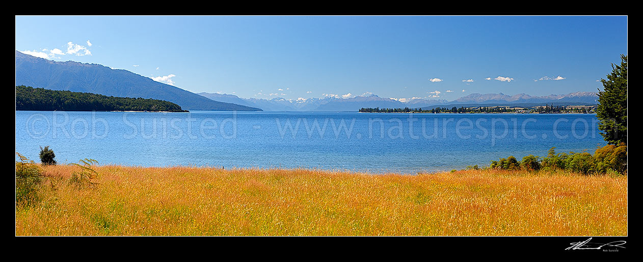 Image of Lake Te Anau panorama from the southern end near the Waiau River outlet. Te Anau township far right, Fiordland Mountains distant, Te Anau, Southland District, Southland Region, New Zealand (NZ) stock photo image