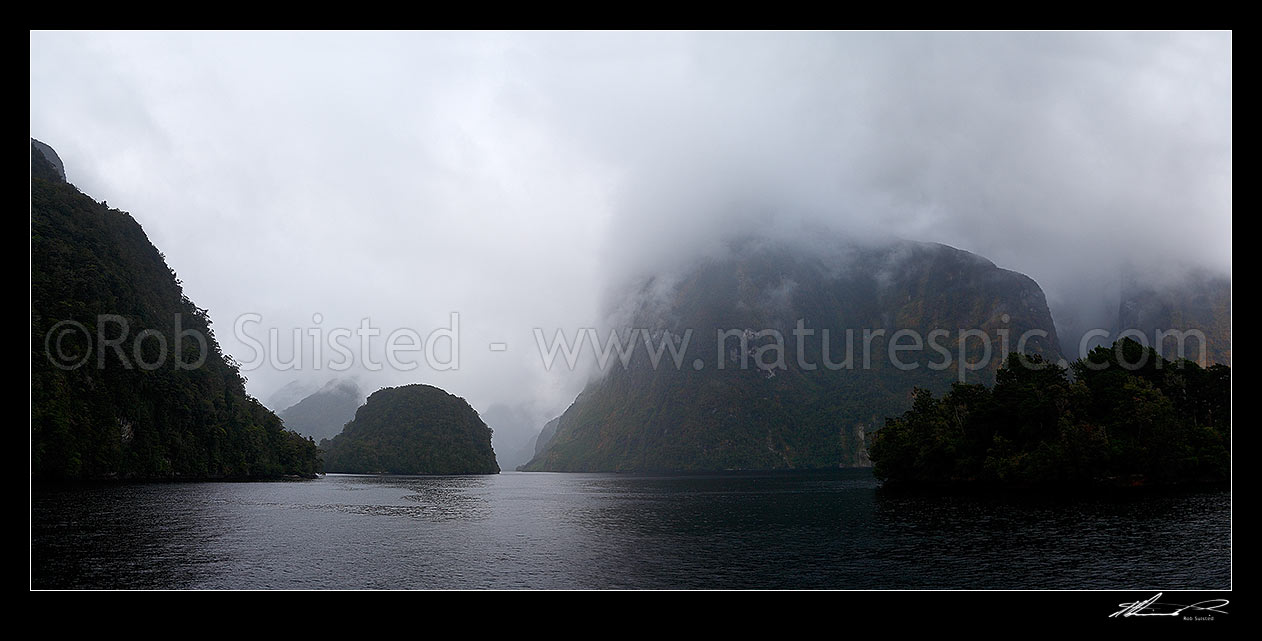 Image of Doubtful Sound on a misty day. Looking up Hall Arm, past Rollo Island and Davidson Head with Commander Peak (1258m) in cloud, Doubtful Sound, Fiordland National Park, Southland District, Southland Region, New Zealand (NZ) stock photo image