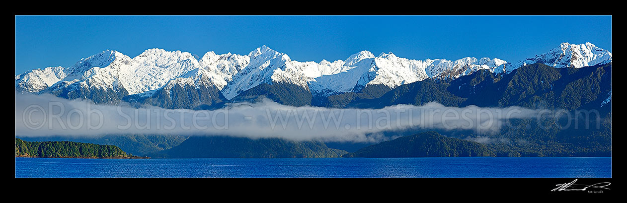 Image of Lake Manapouri surrounded by snow capped mountains in winter. Panorama, Manapouri, Southland District, Southland Region, New Zealand (NZ) stock photo image