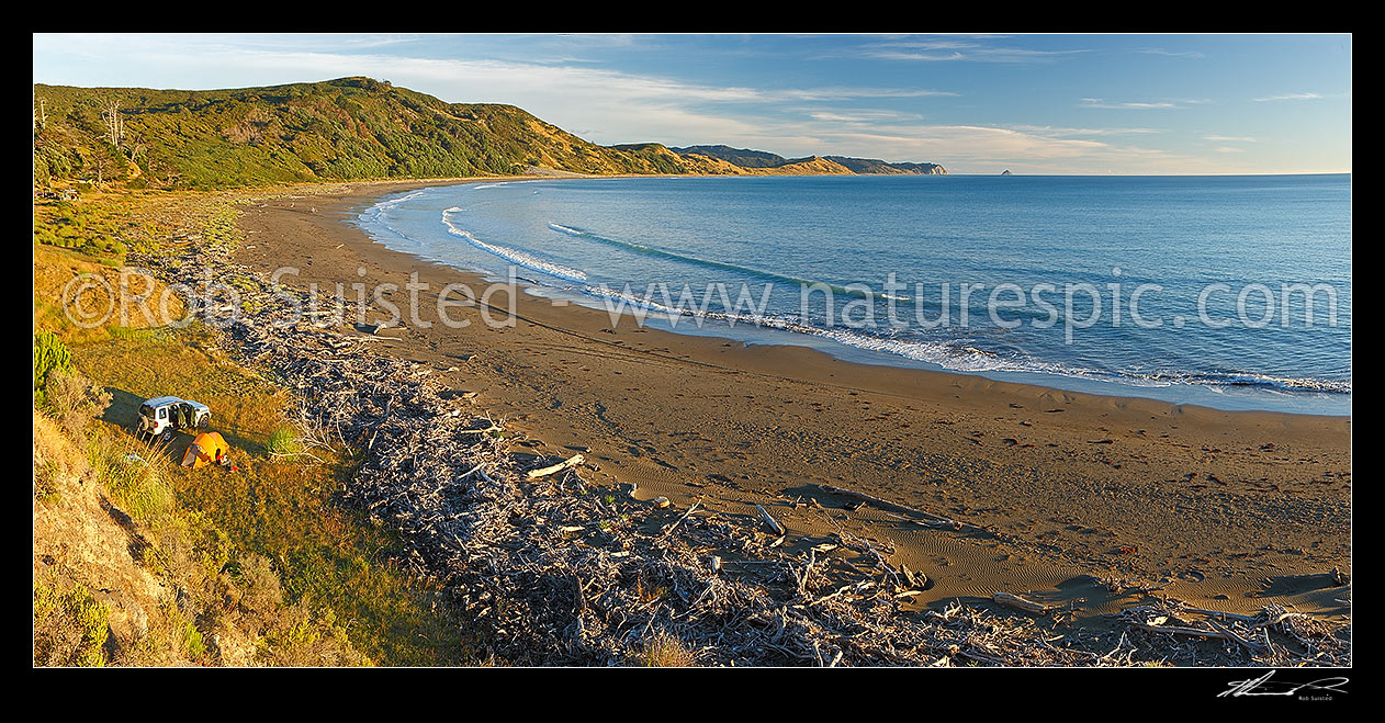 Image of Port Awanui and Te Wharau Beach with tent campers enjoying summer morning. East Cape and East Island (Whangaokeno) visible in distance. Panorama, Port Awanui, East Coast, Gisborne District, Gisborne Region, New Zealand (NZ) stock photo image