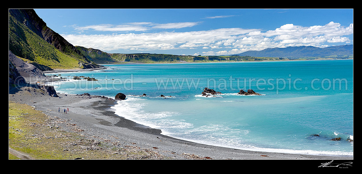 Image of Palliser Bay coast panorama looking towards Ocean Beach with a family walking on the beach. Aorangi Haurangi Range beyond, Ocean Beach, South Wairarapa District, Wellington Region, New Zealand (NZ) stock photo image