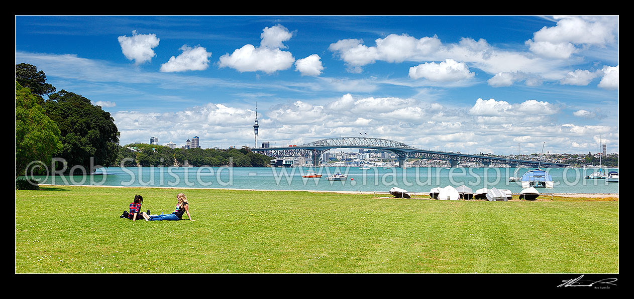 Image of Auckland City, Harbour bridge and Sky Tower from the North Shore, with people enjoying sunny weather. Panorama, Auckland, North Shore City District, Auckland Region, New Zealand (NZ) stock photo image