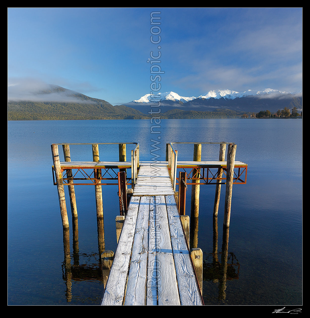 Image of  Lake Te Anau jetty on a calm frosty morning in winter with the Murchison Mountains behind in snow. Square format, Lake Te Anau, Fiordland National Park, Southland District, Southland Region, New Zealand (NZ) stock photo image