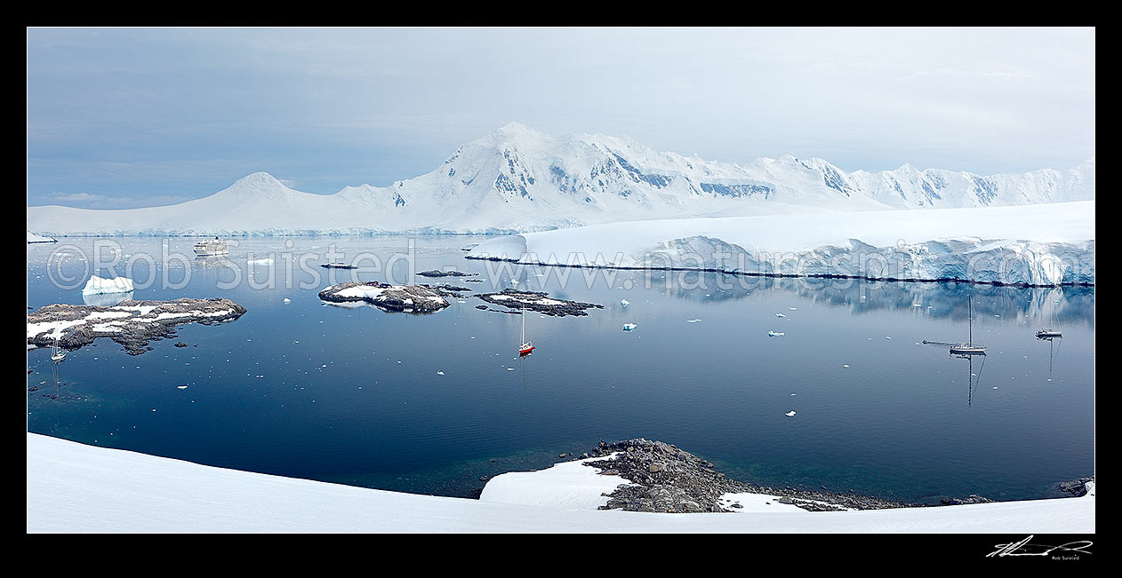 Image of Port Lockroy panorama with four yachts moored near the historic base on a clam day. Neumayer Channel behind, Antarctic Peninsula, Antarctica Region, Antarctica stock photo image