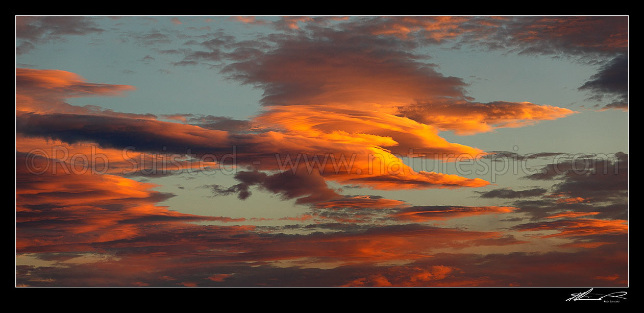 Image of Unusual fiery orange sunset clouds in an evening sky. Panorama file, New Zealand (NZ) stock photo image