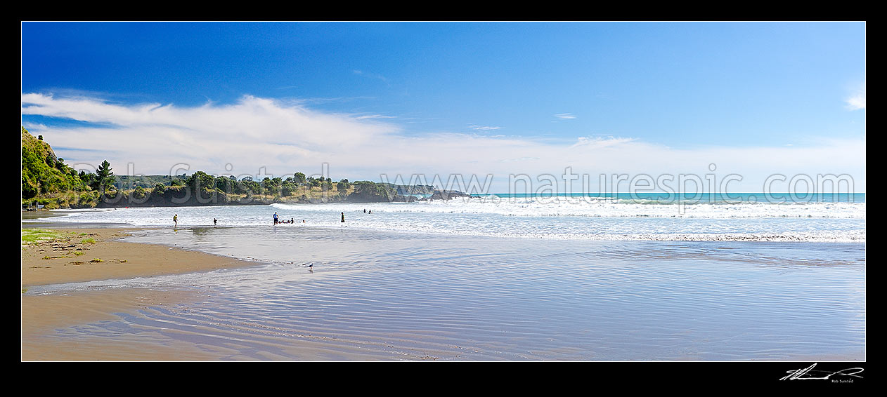 Image of Onepoto Bay and Beach with people and family swimming and bodyboarding in surf. Summertime panorama, Hicks Bay, Gisborne District, Gisborne Region, New Zealand (NZ) stock photo image