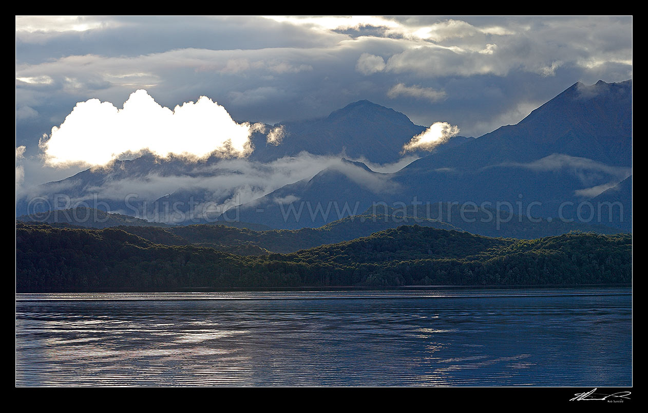 Image of Lake Te Anau and Fiordland, with the Murchison Mountains beyond as mist lifts in the evening. Mt Owen centre, Fiordland National Park, Southland District, Southland Region, New Zealand (NZ) stock photo image