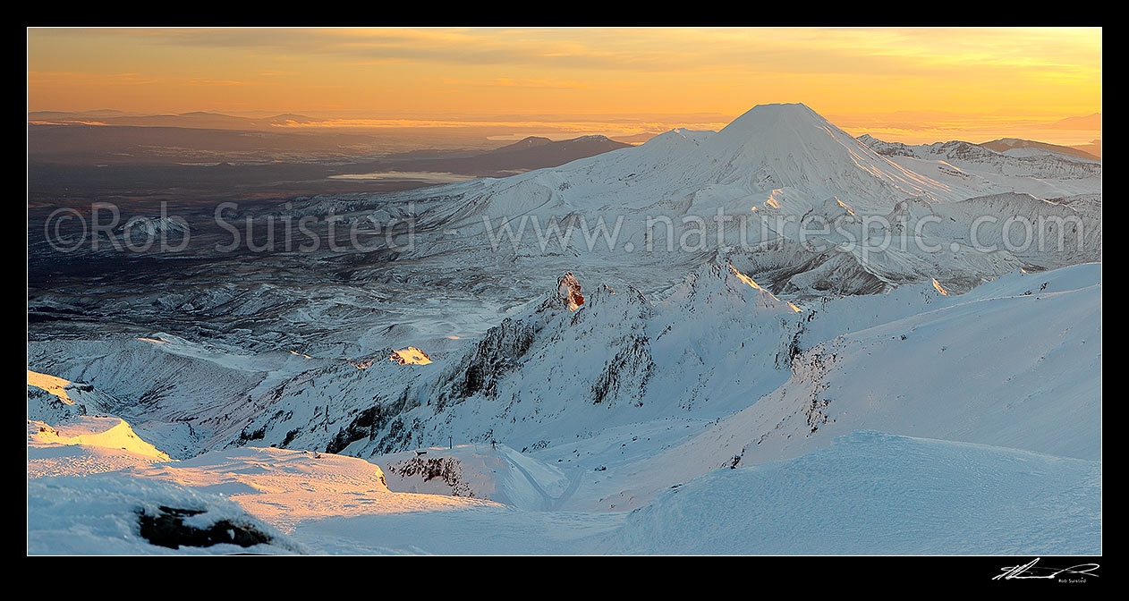 Image of Mount Ngauruhoe sunrise (2287m) from Mt Ruapehu. Pinnacle Ridge and Whakapapa in foreground. Mt Tongariro (1967m) and Lake Taupo behind. Heavy winter snow. Panorama, Tongariro National Park, Ruapehu District, Manawatu-Wanganui Region, New Zealand (NZ) stock photo image