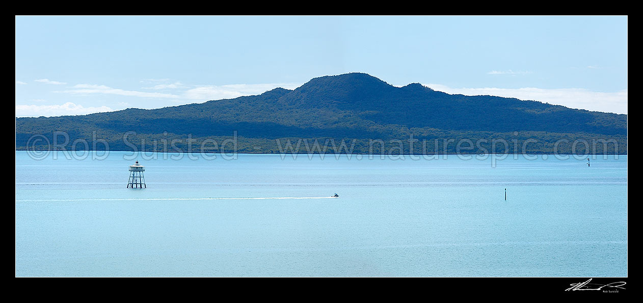 Image of Rangitoto Island volcanic cone and the Motukorea Channel with pleasure boat passing Bean Rock lighthouse guarding Bean Rocks. Panorama, Rangitoto Island, Auckland City District, Auckland Region, New Zealand (NZ) stock photo image