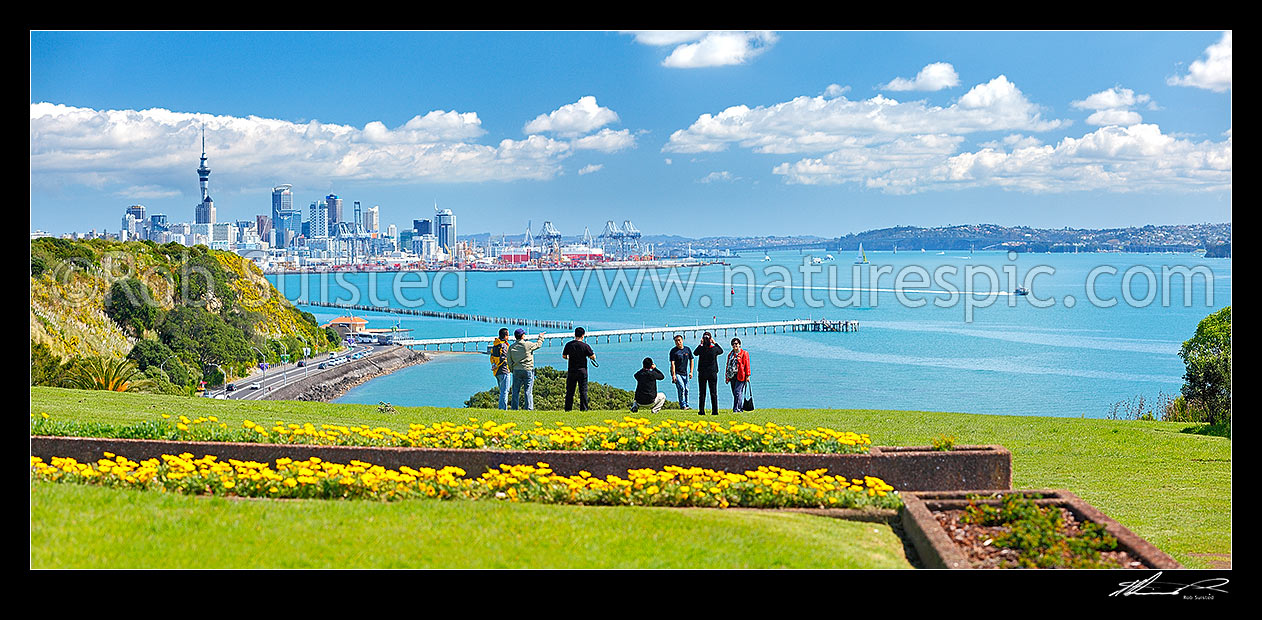 Image of Auckland City, waterfront and Waitemata Harbour photo from near Mission Bay. Asian tourists taking photos with ferries and yachts behind. Bastion Point. Panorama, Auckland City, Auckland City District, Auckland Region, New Zealand (NZ) stock photo image