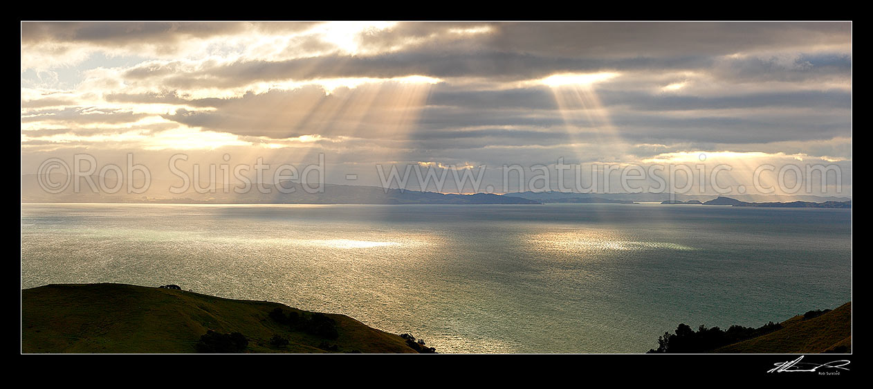 Image of Hauraki Gulf with moody sunshafts and clouds over sea near Kirita Bay, Coromandel Peninsula, looking towards Auckland. Panorama, Coromandel, Thames-Coromandel District, Waikato Region, New Zealand (NZ) stock photo image