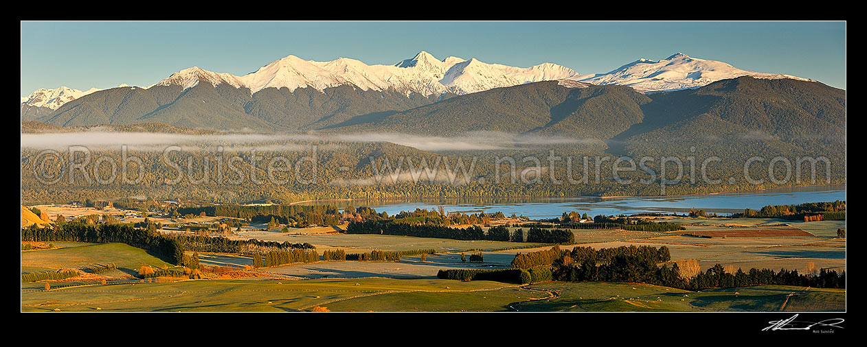 Image of Lake Te Anau and Te Anau township, with winter snow capped Murchison Mountains and Fiordland National Park beyond. Panorama, Te Anau, Fiordland National Park, Southland District, Southland Region, New Zealand (NZ) stock photo image