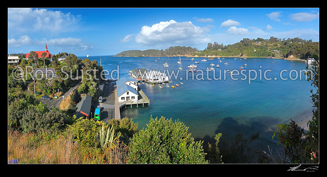 Image of Halfmoon Bay, wharf, and fishing boats moored in the bay at the main town on Stewart Island, Rakiura. Panorama, Halfmoon Bay, Oban, Stewart Island District, Southland Region, New Zealand (NZ) stock photo image