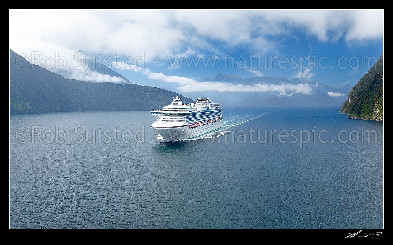 Image of Cruise ship in Pendulo Reach between Thompson, Bradshaw and Doubtful Sounds. Princess Cruises Diamond Princess vessel with Secretary Island at left. Aerial panorama, Doubtful Sound, Fiordland National Park, Southland District, Southland Region, New Zealand (NZ) stock photo image