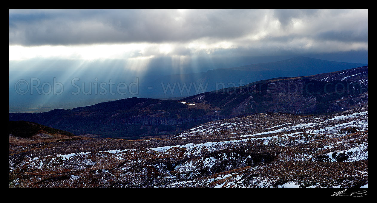 Image of Lake Surprise and Maungaturuturu River valley lit by sun shafts behind a passing weather front on the flanks of Mount Ruapehu near Ohakune. Panorama, Tongariro National Park, Ruapehu District, Manawatu-Wanganui Region, New Zealand (NZ) stock photo image