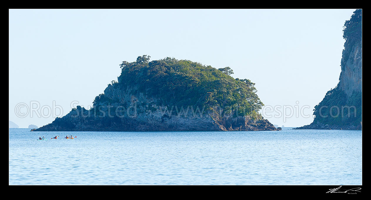 Image of Sea kayakers in Whanganui A Hei Marine Reserve, with Poikeke Island centre and Motueka (Pigeon) Islands right. Cathedral Cove. Panorama, Hahei, Coromandel Peninsula, Thames-Coromandel District, Waikato Region, New Zealand (NZ) stock photo image