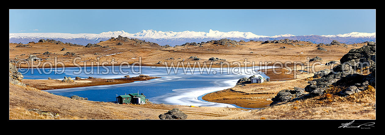 Image of Poolburn reservior frozen in winter with fishing baches and cribs around edge, used as the Lord of the Rings location Rohan. Panorama, Ida Burn Valley, Central Otago District, Otago Region, New Zealand (NZ) stock photo image