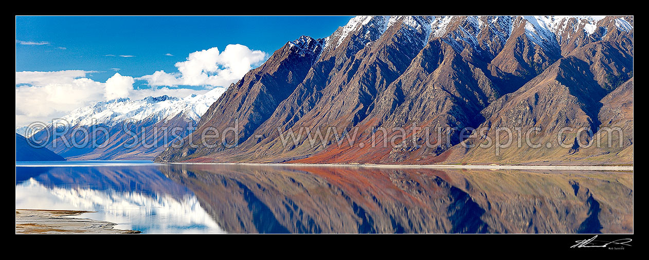 Image of Lake Hawea with the snow covered Huxley Range and mountains reflecting in lake. Hunter River Valley far left. Panorama, Lake Hawea, Otago, Queenstown Lakes District, Otago Region, New Zealand (NZ) stock photo image