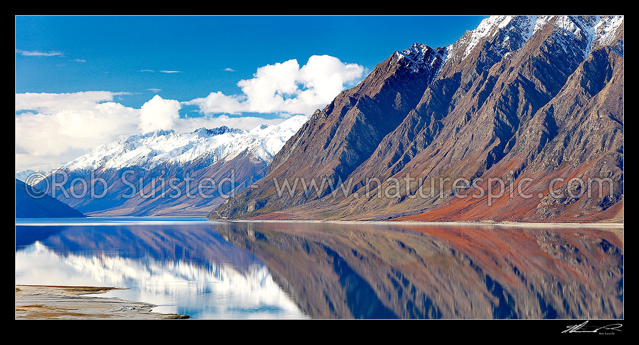 Image of Lake Hawea with the snow covered Huxley Range and mountains reflecting in lake. Hunter River Valley far left. Panorama, Lake Hawea, Otago, Queenstown Lakes District, Otago Region, New Zealand (NZ) stock photo image