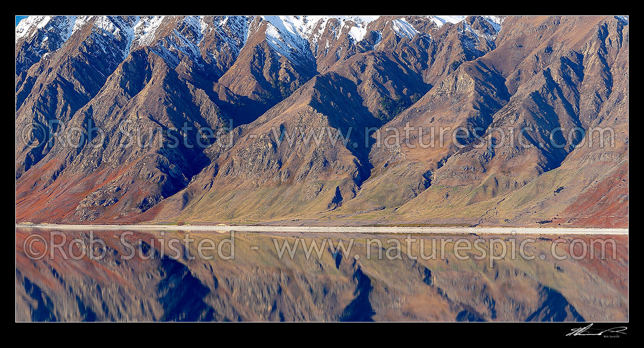 Image of Lake Hawea with snow covered rugged mountains reflecting in lake. Panorama, Lake Hawea, Otago, Queenstown Lakes District, Otago Region, New Zealand (NZ) stock photo image