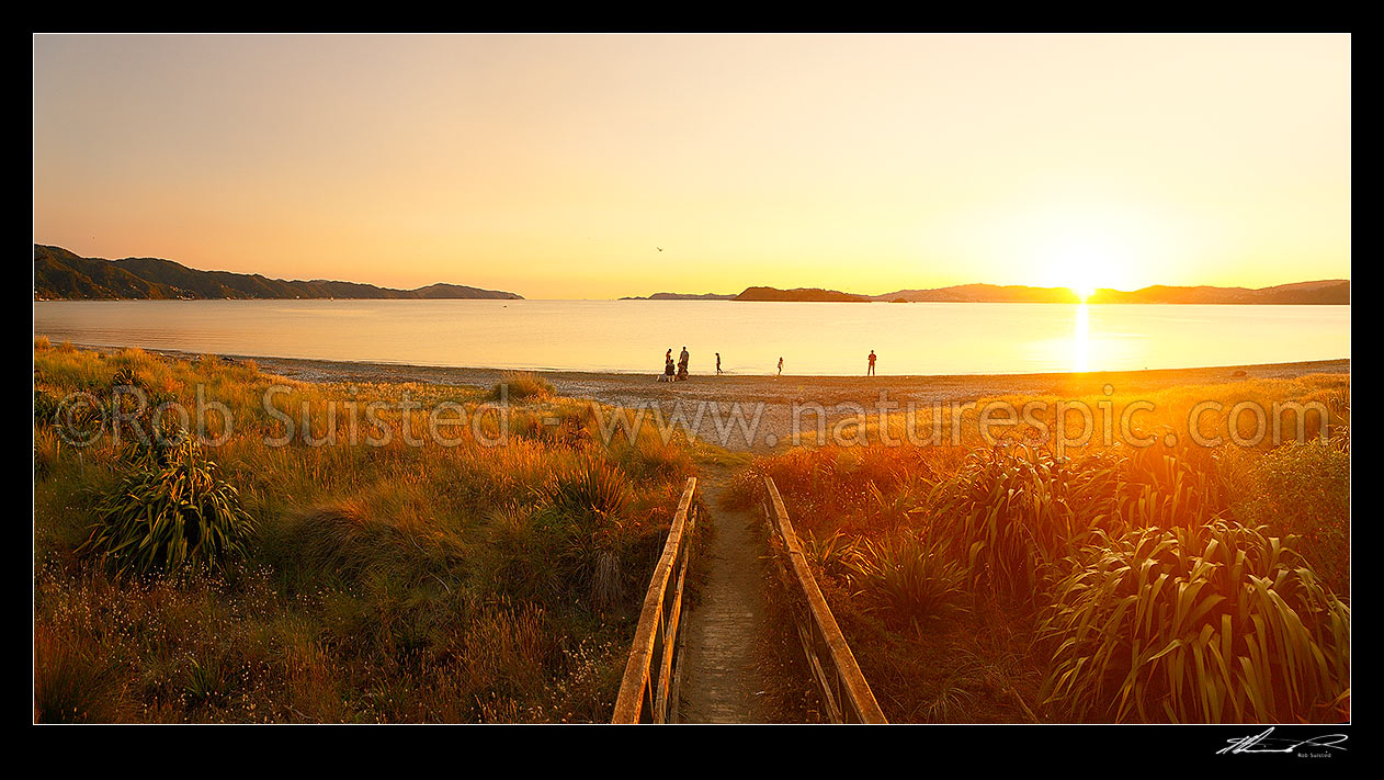 Image of People enjoying a perfect Petone Beach sunset with Wellington Harbour entrance and city beyond. Panorama, Petone, Hutt City District, Wellington Region, New Zealand (NZ) stock photo image