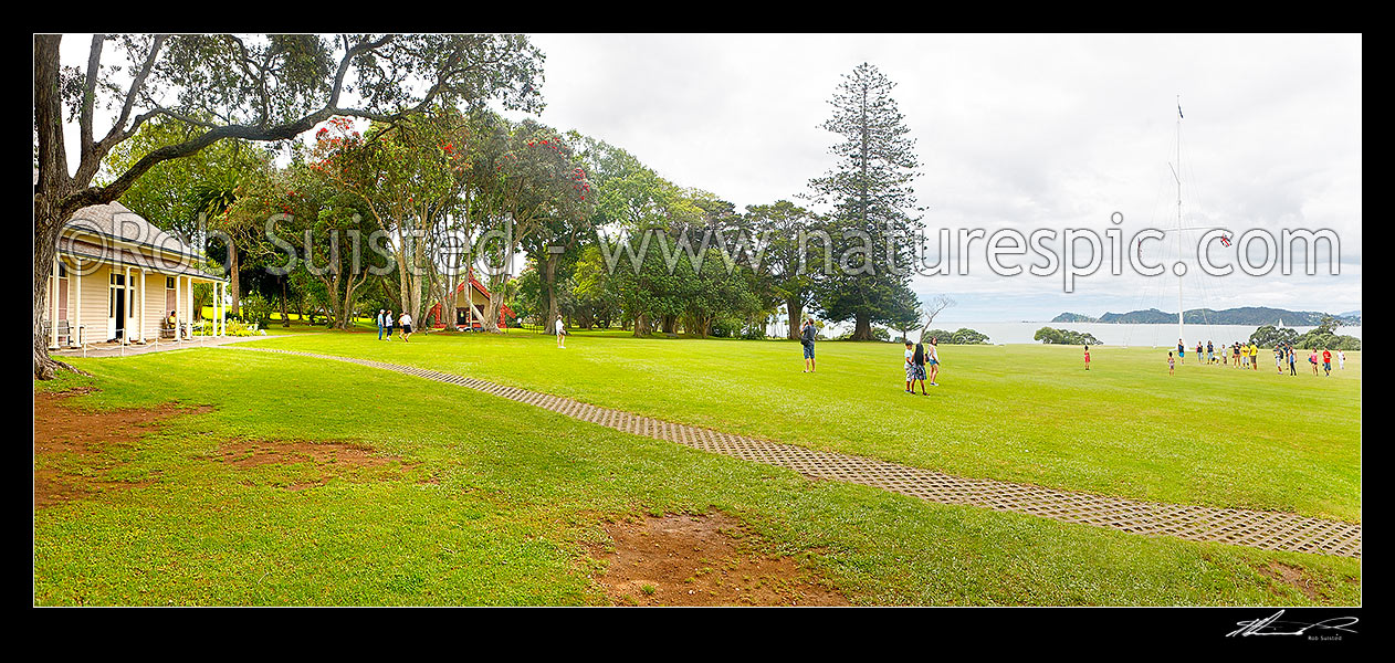 Image of The Treaty House (1834 - left) and Te Whare Runanga (1940 - centre left) and imposing Naval flagstaff (right) at the Waitangi Treaty Grounds. Te Tiriti o Waitangi. Panorama, Paihia, Bay of Islands, Far North District, Northland Region, New Zealand (NZ) stock photo image