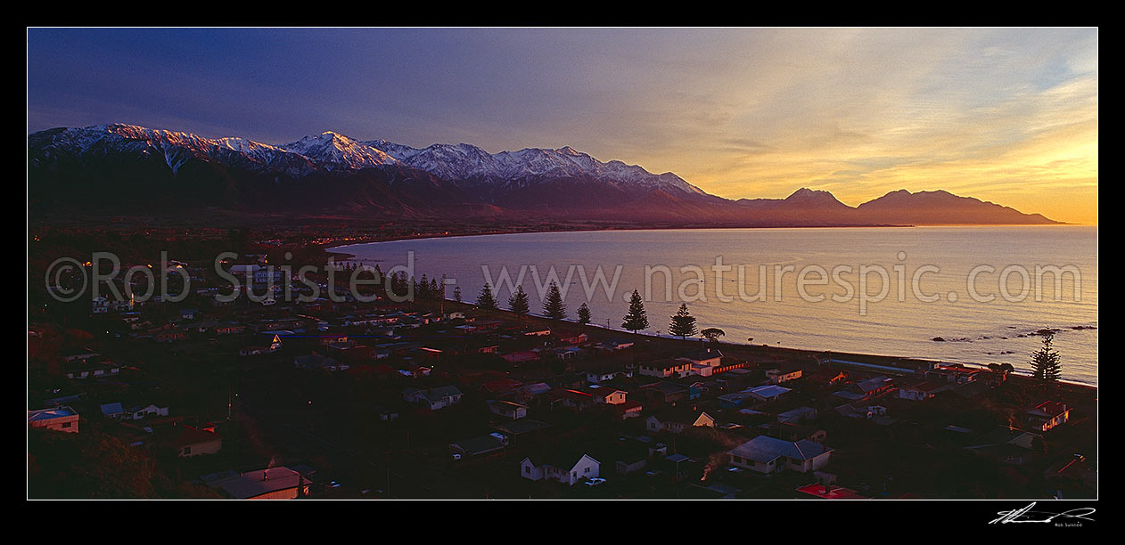 Image of Kaikoura township at dawn. Snow covered Seaward Kaikoura Range and Mt Fyffe beyond. Panorama, Kaikoura, Kaikoura District, Canterbury Region, New Zealand (NZ) stock photo image