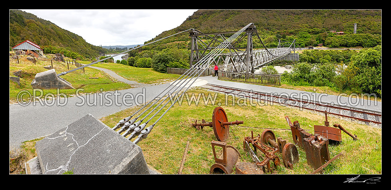 Image of Brunner Suspension Bridge over the Grey River at the historic Brunner Mine Site, one of NZ's earliest industrial sites from 1860's onwards. Stillwater. Panorama, Taylorville, Grey District, West Coast Region, New Zealand (NZ) stock photo image