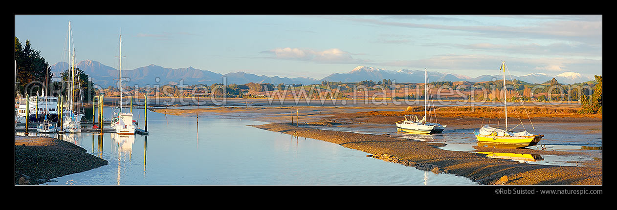 Image of Port Motueka Marina with boats moored in Moutere Inlet at low tide. Richmond Range in distance. Panorama, Motueka, Tasman District, Tasman Region, New Zealand (NZ) stock photo image