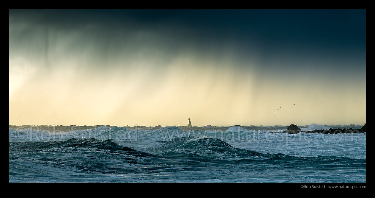 Image of Karori Rock lighthouse in a winter southerly storm sea surge blowing in from Cook Strait. Sleetly rain showers above. Tongue Point. Panorama, Wellington South Coast, Wellington City District, Wellington Region, New Zealand (NZ) stock photo image