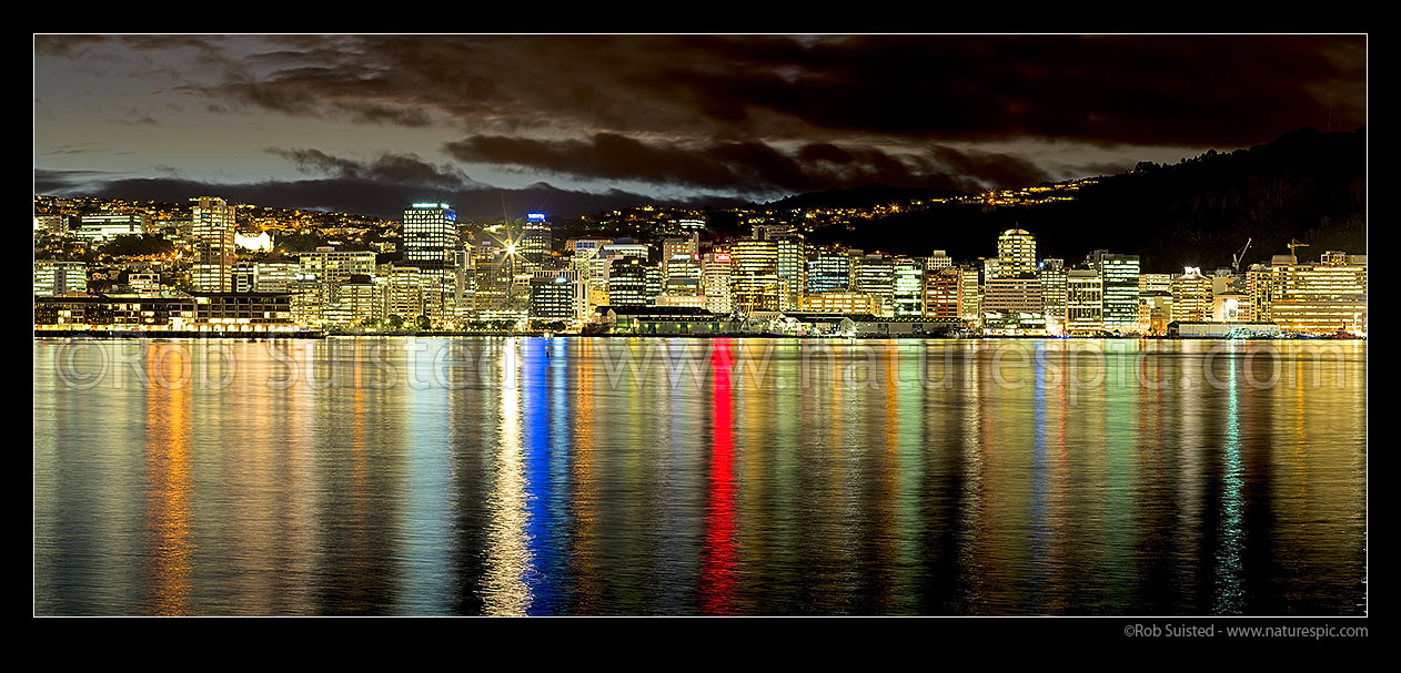 Image of Wellington City CBD skyline and building lights at twilight, reflecting on Lambton Harbour. Panorama, Wellington, Wellington City District, Wellington Region, New Zealand (NZ) stock photo image