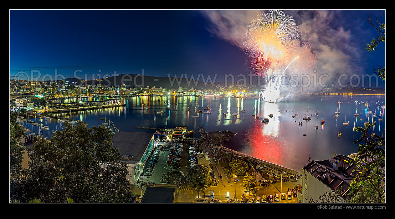 Image of Fireworks in Wellington City off Oriental Bay with spectators lining the shore or in private boats. Panorama, Wellington, Wellington City District, Wellington Region, New Zealand (NZ) stock photo image