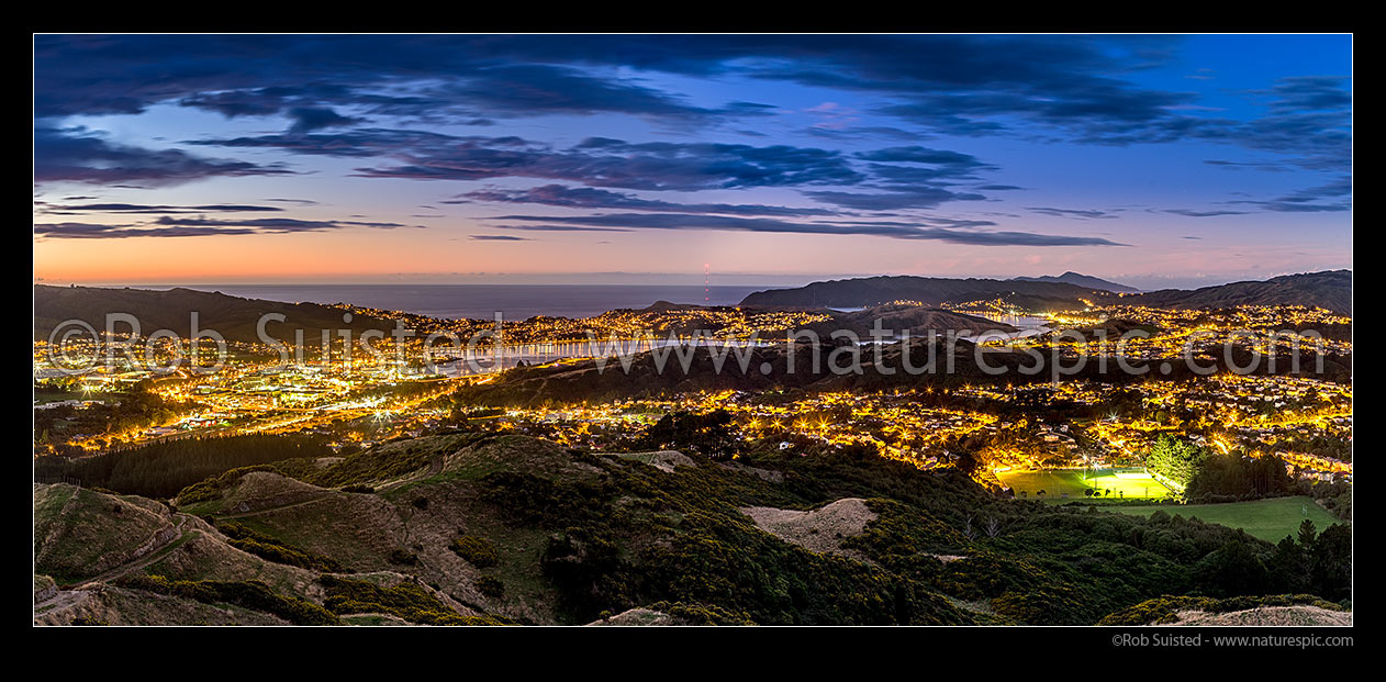 Image of Porirua City and harbour at sunset. Porirua East, Ranui Heights and Cannons Creek foreground. Titahi Bay, Plimmerton, Mana, Paremata and Kapiti Island beyond. Panorama, Porirua, Porirua City District, Wellington Region, New Zealand (NZ) stock photo image