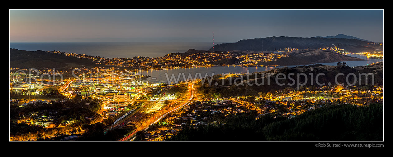 Image of Porirua City and harbour after sunset. Porirua East, Ranui Heights and Cannons Creek foreground. Titahi Bay, Plimmerton, and Kapiti Island beyond. Panorama, Porirua, Porirua City District, Wellington Region, New Zealand (NZ) stock photo image